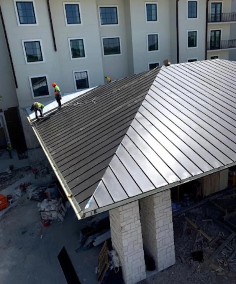 Crew installing standing seam metal roof panels on a commercial project in Wauchula